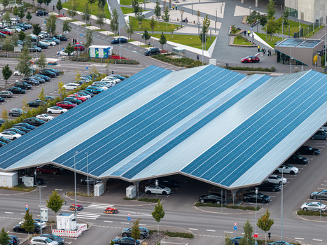 Aerial view of Tesla Gigafactory Berlin Brandenburg featuring a solar panel roof over a parking area with electric vehicles in Grunheide Mark Brandenburg Germany. Aerial view of Tesla Gigafactory Berlin Brandenburg featuring a solar panel roof over a parking area with electric vehicles in Grunheide Mark Brandenburg Germany.