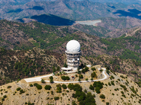 Aerial view of Kionia radar station situated on a mountain peak surrounded by rugged forested hills and rocky terrain under a clear sky Lazanias Lefkosia Cyprus. Aerial view of Kionia radar station situated on a mountain peak surrounded by rugged forested hills and rocky terrain under a clear sky Lazanias Lefkosia Cyprus.