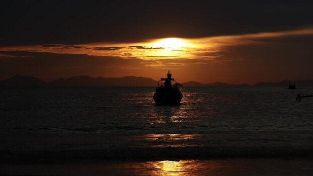View of a boat at sunset over the sea Thailand.