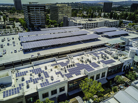 Aerial view of solar panel infrastructure on a parking garage roof and commercial building featuring photovoltaic cells and urban architecture in San Fernando California United States. Aerial view of solar panel infrastructure on a parking garage roof and commercial building featuring photovoltaic cells and urban architecture in San Fernando California United States.
