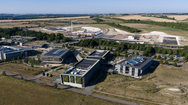 Aerial view of the Wellcome Genome Campus featuring modern research buildings with green roofs and solar panels surrounded by landscaped grounds in Hinxton England United Kingdom. Aerial view of the Wellcome Genome Campus featuring modern research buildings with green roofs and solar panels surrounded by landscaped grounds in Hinxton England United Kingdom.