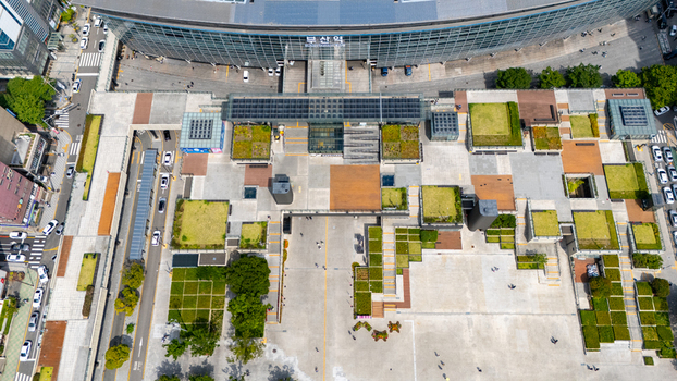 Aerial view of Busan station featuring modern architecture landscaped rooftop gardens and a spacious plaza with pedestrians in Busan Busan South Korea. Aerial view of Busan station featuring modern architecture landscaped rooftop gardens and a spacious plaza with pedestrians in Busan Busan South Korea.