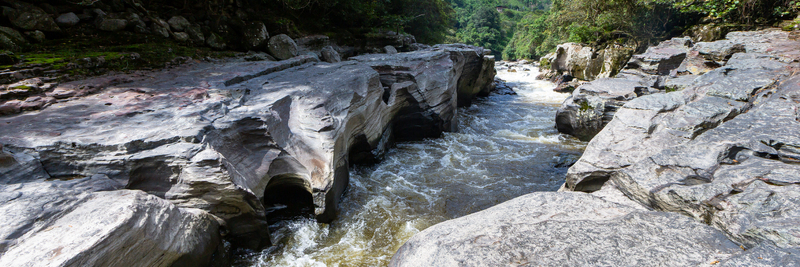 View of the Estrecho del Rio Magdalena with rushing water flowing through narrow eroded volcanic rock formations in San Agustin Huila Colombia.