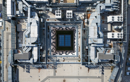 Aerial view of a building s intricate rooftop mechanical systems surrounding a central courtyard with a windowed skylight Bydgoszcz Województwo kujawsko pomorskie Poland. Aerial view of a building s intricate rooftop mechanical systems surrounding a central courtyard with a windowed skylight Bydgoszcz Województwo kujawsko pomorskie Poland.