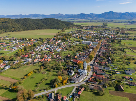 Aerial view of a village with red roofs nestled in a green valley between a dark forest and distant mountains Klastor pod Znievom Zilina Region Slovakia. Aerial view of a village with red roofs nestled in a green valley between a dark forest and distant mountains Klastor pod Znievom Zilina Region Slovakia.