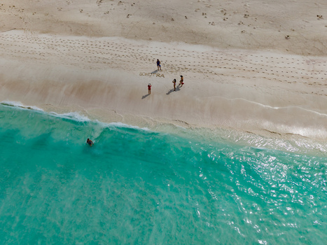 Aerial view of turquoise waters meeting the pristine sands where people gather near Socotra written in the sand Shoab beach Socotra Yemen. Aerial view of turquoise waters meeting the pristine sands where people gather near Socotra written in the sand Shoab beach Socotra Yemen.