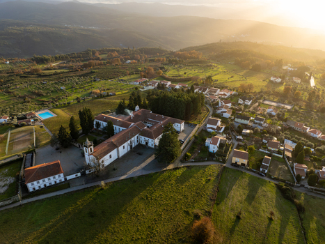 Vila Pouca da Beira Portugal 31 December 2023 Aerial view of Lam Hotel Convento do Desagravo with its historic bell tower green fields and rural houses during golden hour. Vila Pouca da Beira Portugal 31 December 2023 Aerial view of Lam Hotel Convento do Desagravo with its historic bell tower green fields and rural houses during golden hour.