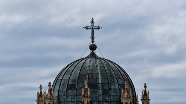 Aerial view of the copper dome and cross of the Memorial Presbyterian Church under a cloudy sky in St. Augustine Florida United States.