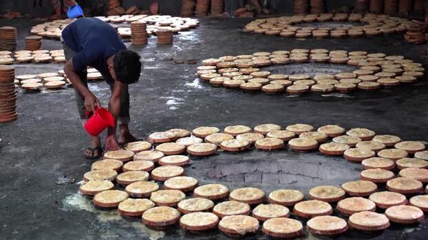 View of a man preparing traditional curd in Bogura Bangladesh. View of a man preparing traditional curd in Bogura Bangladesh.