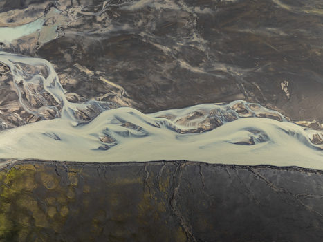 Aerial view of the braided river system at Landmannalaugar with glacial water flowing through dark volcanic terrain and mossy patches in Rangarthing ytra Iceland. Aerial view of the braided river system at Landmannalaugar with glacial water flowing through dark volcanic terrain and mossy patches in Rangarthing ytra Iceland.
