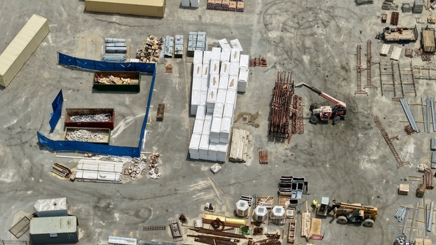 Aerial view of the construction staging area at Foundry Lane with stacks of building materials shipping containers and heavy machinery in World Golf Village Florida United States.