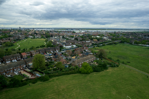 Aerial view of houses nestled among green fields under a cloudy sky Slade green United Kingdom.