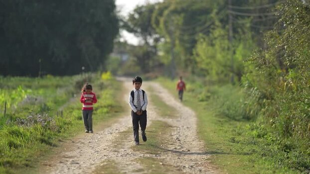 View of children walking on a rural dirt path in Dhangadhi Nepal.