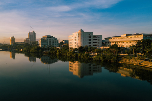 Aerial view of buildings reflecting on the still water of the river under the soft light of dawn Iloilo City Philippines. Aerial view of buildings reflecting on the still water of the river under the soft light of dawn Iloilo City Philippines.