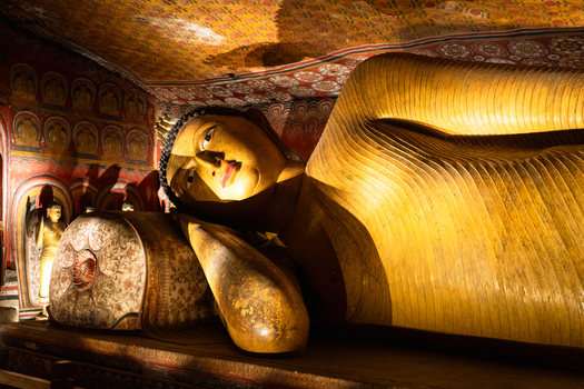 View of the reclining golden Buddha statue and ancient murals inside the Dambulla Cave Temple Dambulla Central Province Sri Lanka.