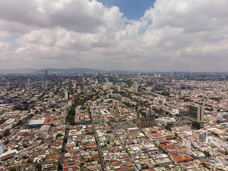 Aerial view of the historic Centro district featuring the Guadalajara Cathedral dense urban rooftops and sprawling city landscape under a cloudy sky in Guadalajara Jalisco Mexico. Aerial view of the historic Centro district featuring the Guadalajara Cathedral dense urban rooftops and sprawling city landscape under a cloudy sky in Guadalajara Jalisco Mexico.
