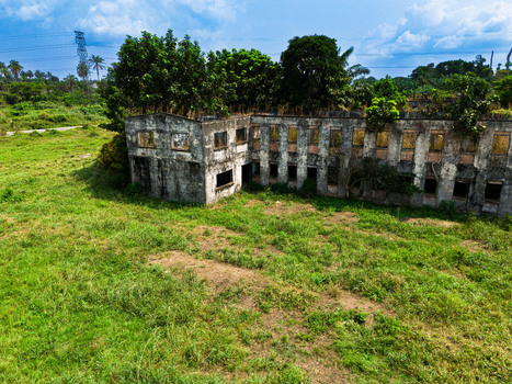 Aerial view of an abandoned concrete building overgrown with lush green trees and vegetation in a grassy field Ahoada I Rivers Nigeria. Aerial view of an abandoned concrete building overgrown with lush green trees and vegetation in a grassy field Ahoada I Rivers Nigeria.