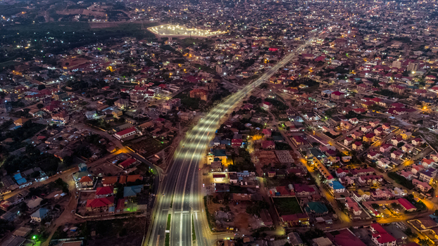 Aerial view of the illuminated Pokuase Interchange at night featuring multi level highway infrastructure and dense urban residential rooftops in Ga North Municipal Greater Accra Region Ghana. Aerial view of the illuminated Pokuase Interchange at night featuring multi level highway infrastructure and dense urban residential rooftops in Ga North Municipal Greater Accra Region Ghana.