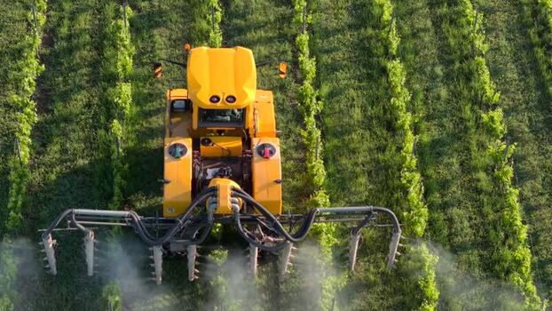 Aerial view of a tractor spraying vines in a vineyard France. Aerial view of a tractor spraying vines in a vineyard France.