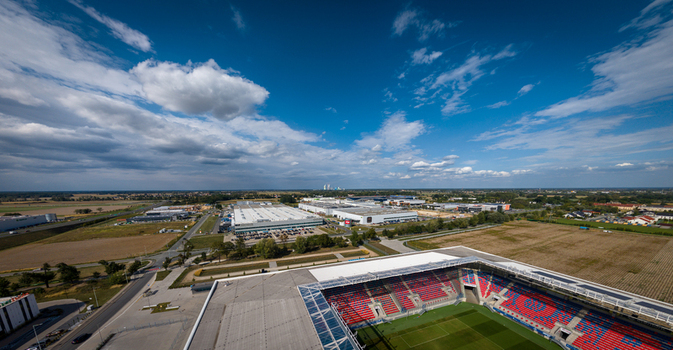 Opole Opole Poland 09 September 2026 Aerial view of CTPark Opole logistics area with Itaka Arena in the foreground and Opole Power Station in the distance under a blue sky.