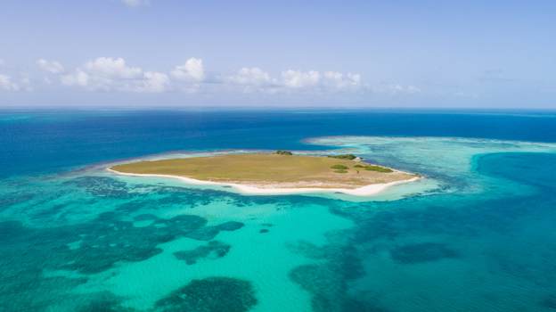 Aerial view of Los Roques archipelago featuring a small island with sandy beaches surrounded by turquoise Caribbean waters and coral reefs in Los Roques Dependencias Federale Venezuela. Aerial view of Los Roques archipelago featuring a small island with sandy beaches surrounded by turquoise Caribbean waters and coral reefs in Los Roques Dependencias Federale Venezuela.