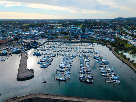 Aerial view of Bangor Harbour and Town featuring numerous sailboats docked in the marina surrounded by urban buildings and coastal landscape in Bangor Northern Ireland United Kingdom.