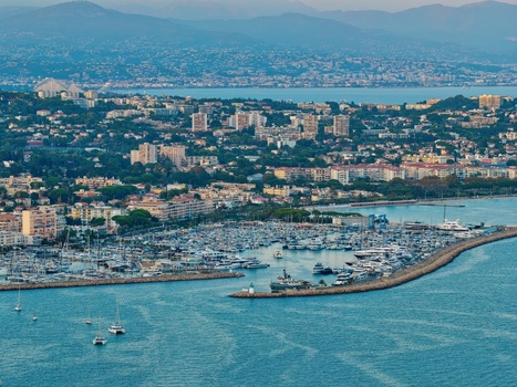 Aerial view of the harbor in Antibes filled with yachts and boats surrounded by the coastal town architecture and the Mediterranean Sea in Antibes Provence Alpes Cote d Azur France. Aerial view of the harbor in Antibes filled with yachts and boats surrounded by the coastal town architecture and the Mediterranean Sea in Antibes Provence Alpes Cote d Azur France.