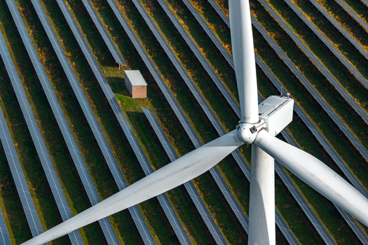 Aerial view of Chelveston Renewable Energy BESS featuring a large wind turbine and rows of solar panels in the green landscape of Chelveston England United Kingdom. Aerial view of Chelveston Renewable Energy BESS featuring a large wind turbine and rows of solar panels in the green landscape of Chelveston England United Kingdom.