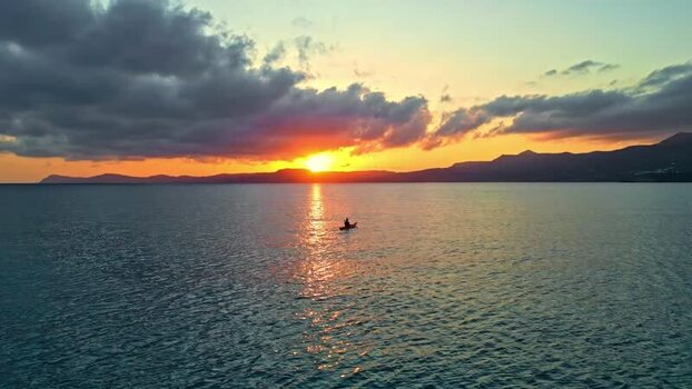 Aerial view of a kayaker on the sea at sunset in Crete Greece.