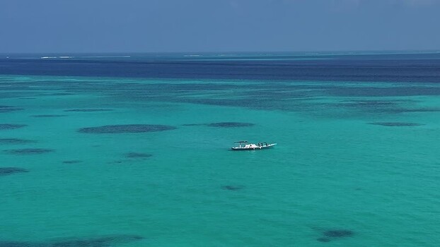 Aerial view of a boat on turquoise water in Maldives. Aerial view of a boat on turquoise water in Maldives.