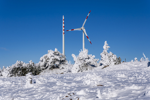 View of a snow covered landscape with wind turbines standing tall against the stark blue sky a serene winter scene Sasbach Baden Württemberg Germany. View of a snow covered landscape with wind turbines standing tall against the stark blue sky a serene winter scene Sasbach Baden Württemberg Germany.