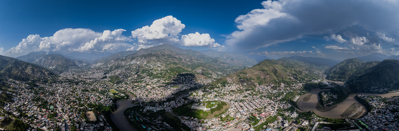 Aerial view of Muzaffarabad nestled in the Himalayan valley with the Jhelum and Neelum rivers converging surrounded by mountains under a blue sky in Muzaffarabad Azad Kashmir Pakistan. Aerial view of Muzaffarabad nestled in the Himalayan valley with the Jhelum and Neelum rivers converging surrounded by mountains under a blue sky in Muzaffarabad Azad Kashmir Pakistan.