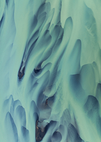 Aerial view of glacial river patterns creating an abstract landscape of icy blues and muted greens Iceland Iceland. Aerial view of glacial river patterns creating an abstract landscape of icy blues and muted greens Iceland Iceland.