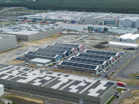 Aerial view of the Tesla Gigafactory Berlin Brandenburg with solar panel arrays on industrial rooftops surrounded by forest and infrastructure in Grunheide Mark Brandenburg Germany. Aerial view of the Tesla Gigafactory Berlin Brandenburg with solar panel arrays on industrial rooftops surrounded by forest and infrastructure in Grunheide Mark Brandenburg Germany.