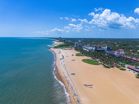 Aerial view of Negombo Beach with golden sand turquoise ocean waves palm trees and coastal resorts under a bright blue sky in Negombo Western Province Sri Lanka. Aerial view of Negombo Beach with golden sand turquoise ocean waves palm trees and coastal resorts under a bright blue sky in Negombo Western Province Sri Lanka.
