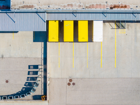 Aerial view of Logistikzentrum Allhaming with yellow and white shipping containers parked at loading bays in a concrete yard in Allhaming Oberosterreich Austria. Aerial view of Logistikzentrum Allhaming with yellow and white shipping containers parked at loading bays in a concrete yard in Allhaming Oberosterreich Austria.