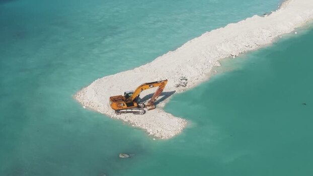 Aerial view of an excavator on a sand spit in the Maldives.