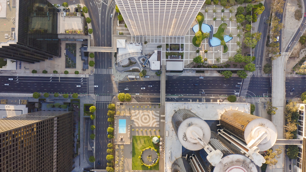 Aerial view of a modern urban intersection surrounded by skyscrapers landscaped plazas and city streets in Los Angeles California United States.