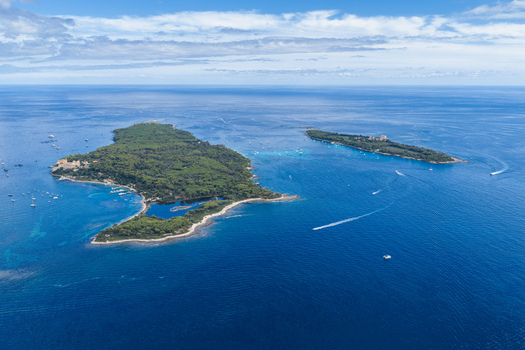 Aerial view of the Lerins Islands including Ile Sainte Marguerite and Ile Saint Honorat surrounded by turquoise Mediterranean waters with boats in Cannes Provence Alpes Cote d Azur France. Aerial view of the Lerins Islands including Ile Sainte Marguerite and Ile Saint Honorat surrounded by turquoise Mediterranean waters with boats in Cannes Provence Alpes Cote d Azur France.