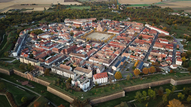Aerial view of the Vauban walled city of Neuf Brisach showcasing its historic star shaped fortifications dense red tiled rooftops and central square in Neuf Brisach Grand Est France. Aerial view of the Vauban walled city of Neuf Brisach showcasing its historic star shaped fortifications dense red tiled rooftops and central square in Neuf Brisach Grand Est France.