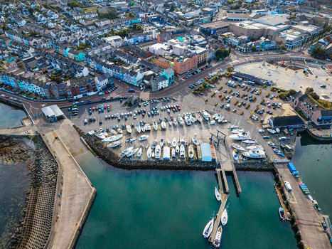 Aerial view of Bangor Harbour and Town featuring numerous sailboats moored in the marina a large parking area and the surrounding urban landscape of Bangor Northern Ireland United Kingdom.