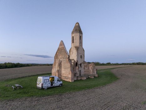Aerial view of the historic Pusztatorony ruined church with a camper van parked on the grassy field in Somogyvamos Hungary. Aerial view of the historic Pusztatorony ruined church with a camper van parked on the grassy field in Somogyvamos Hungary.