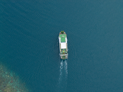 Aerial view of a lone ferry cutting through the deep blue sea leaving a foamy white trail behind Karimunjawa Jawa Tengah Indonesia. Aerial view of a lone ferry cutting through the deep blue sea leaving a foamy white trail behind Karimunjawa Jawa Tengah Indonesia.