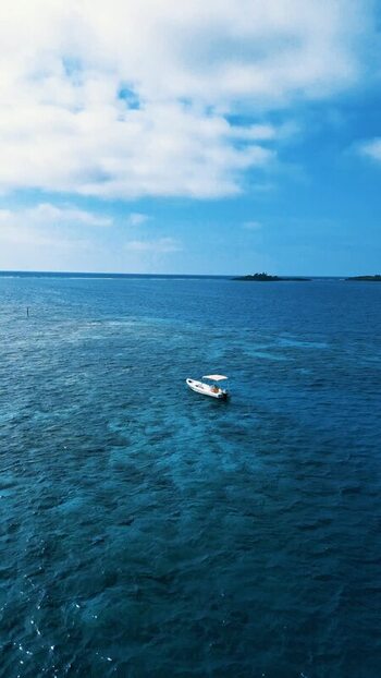 Aerial view of a small boat on turquoise waters in Guanaja Honduras.