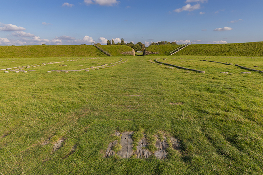 View of The Viking Fortress Trelleborg with its historic earthen ramparts and stone foundations set in a grassy field under a clear blue sky in Slagelse Sjaelland Denmark. View of The Viking Fortress Trelleborg with its historic earthen ramparts and stone foundations set in a grassy field under a clear blue sky in Slagelse Sjaelland Denmark.