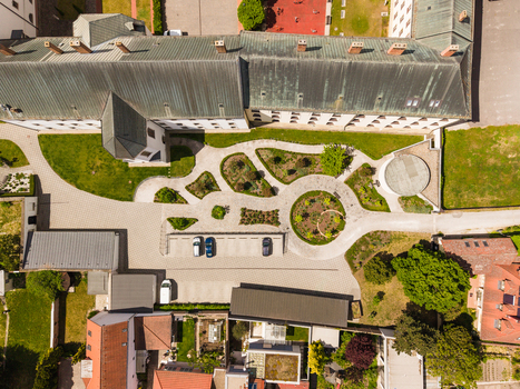 Aerial view of a historic building courtyard featuring geometric paved paths circular garden beds and green lawns in Trnava Trnava Region Slovakia. Aerial view of a historic building courtyard featuring geometric paved paths circular garden beds and green lawns in Trnava Trnava Region Slovakia.