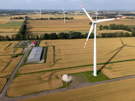 Aerial view of a wind turbine in a golden wheat field with a small industrial building and power substation nearby in the rural landscape of Gdansk Pomeranian Voivodeship Poland. Aerial view of a wind turbine in a golden wheat field with a small industrial building and power substation nearby in the rural landscape of Gdansk Pomeranian Voivodeship Poland.