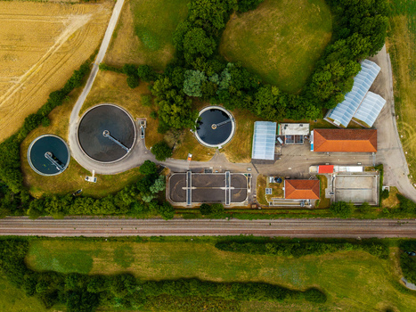 Aerial view of the wastewater treatment plant near Serways Raststatte Hohenlohe Sud with circular tanks and rectangular basins in green fields in Neuenstein Baden Wurttemberg Germany. Aerial view of the wastewater treatment plant near Serways Raststatte Hohenlohe Sud with circular tanks and rectangular basins in green fields in Neuenstein Baden Wurttemberg Germany.