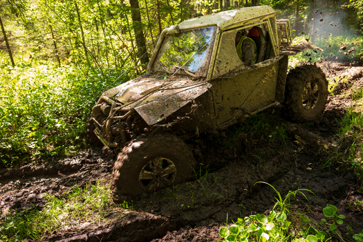 View of an off road vehicle driving through deep mud in a forest near Lake Ladoga in Sortavala Respublika Kareliya Russia.