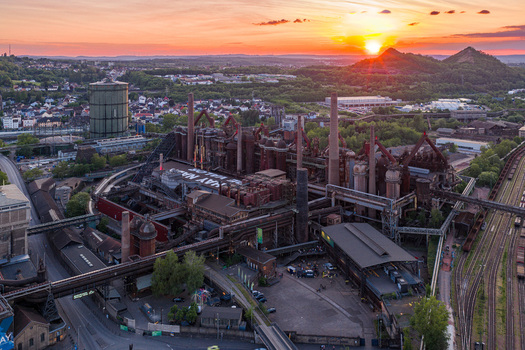 Volklingen Germany 09 May 2026 Aerial view of the Volklingen Ironworks industrial complex with blast furnaces and chimneys under a golden sunset sky. Volklingen Germany 09 May 2026 Aerial view of the Volklingen Ironworks industrial complex with blast furnaces and chimneys under a golden sunset sky.